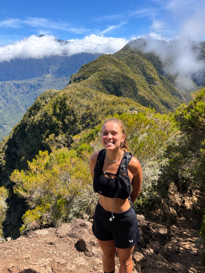 Lucie Deruez souriante en randonnée face aux montagnes